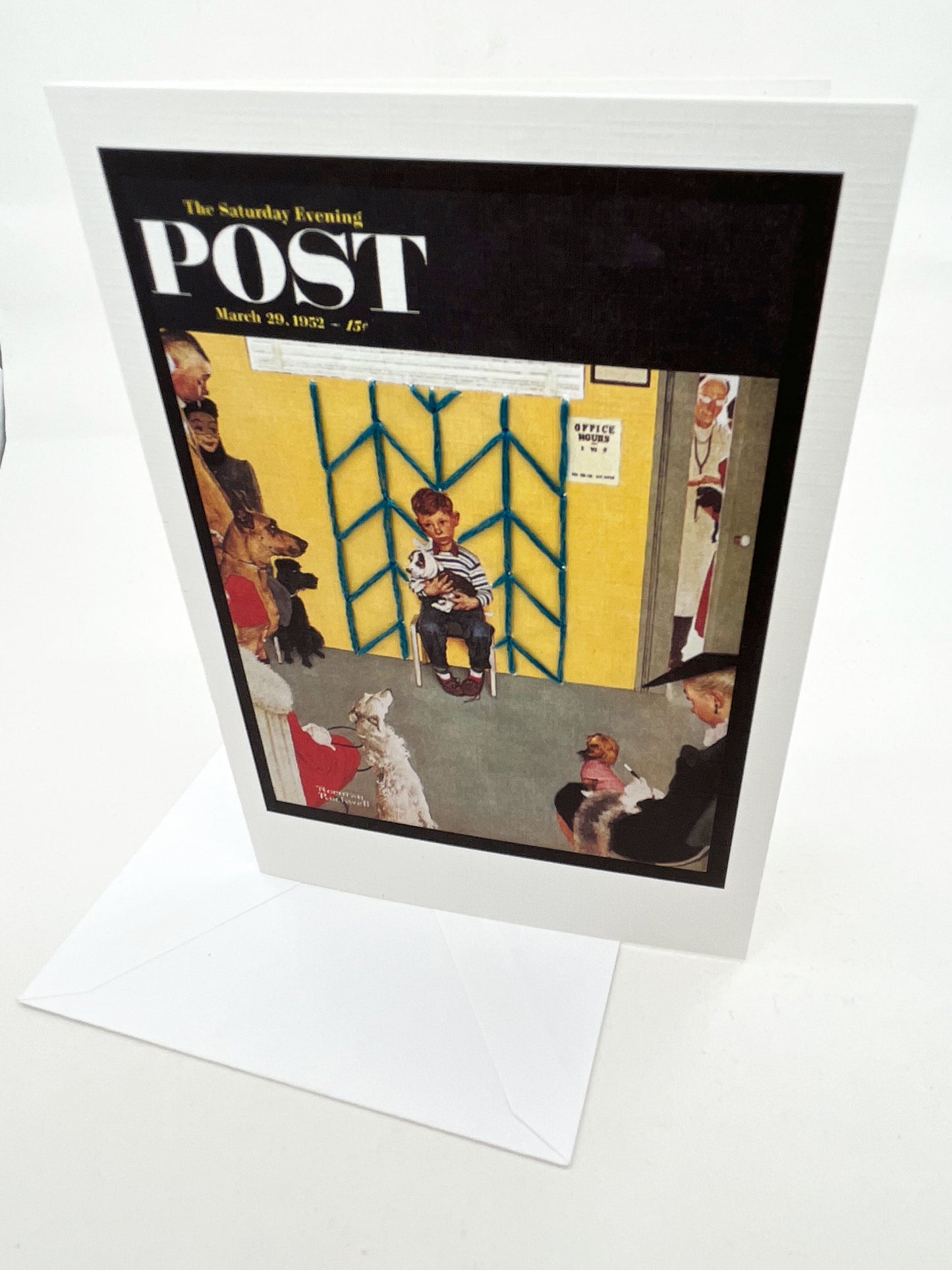 greeting card with a print of an issue of The Saturday Evening Post, a picture of a a boy holding his dog at the vet looking worried, with hand embroidered chevron pattern on the wall behind him