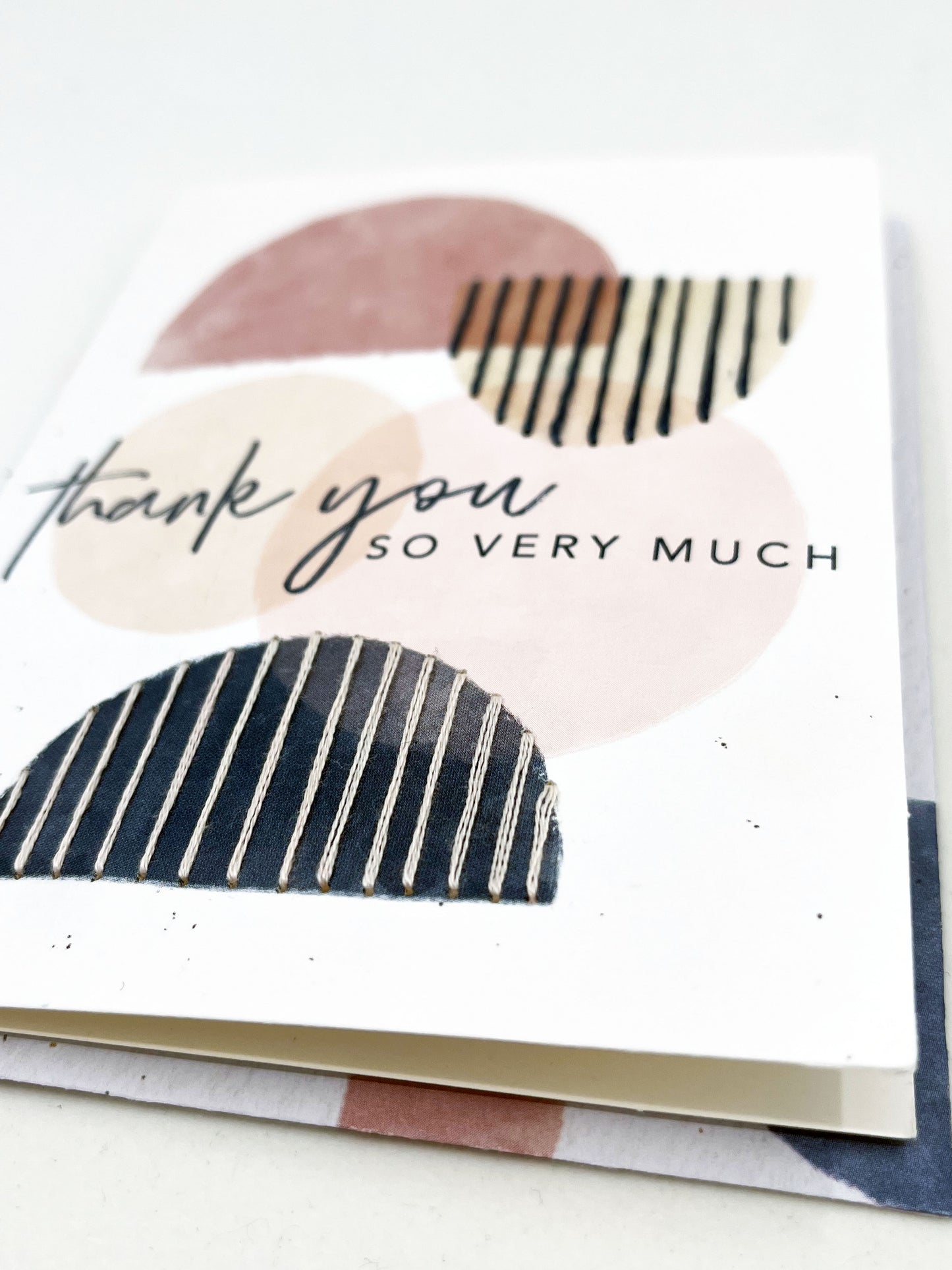 greeting card that says thank you so very much on it, with circles and half circles in mauve peach and navy, some of the half circles are stitched over with vertical lines in contrasting colors
