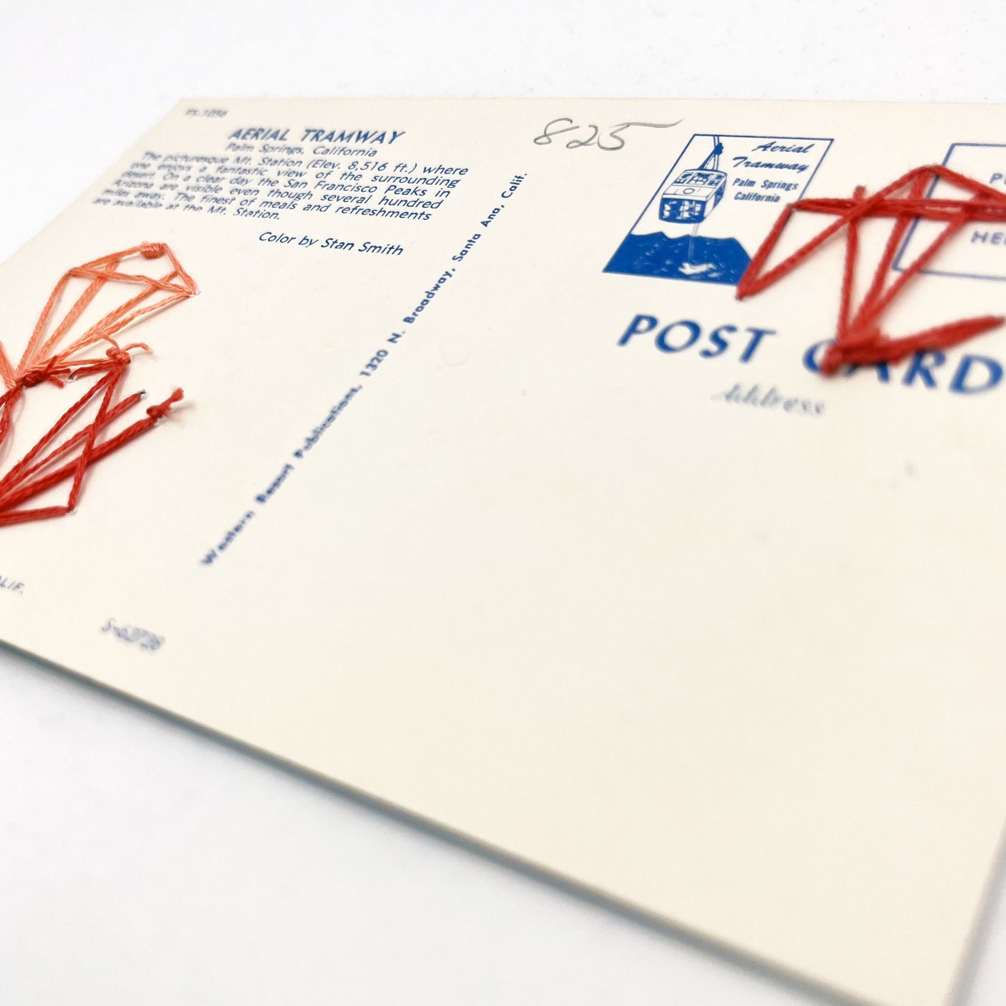 back side of an old postcard of the Palm Springs Aerial Tramway, with coral hand embroidered art deco hexagons randomly placed on it