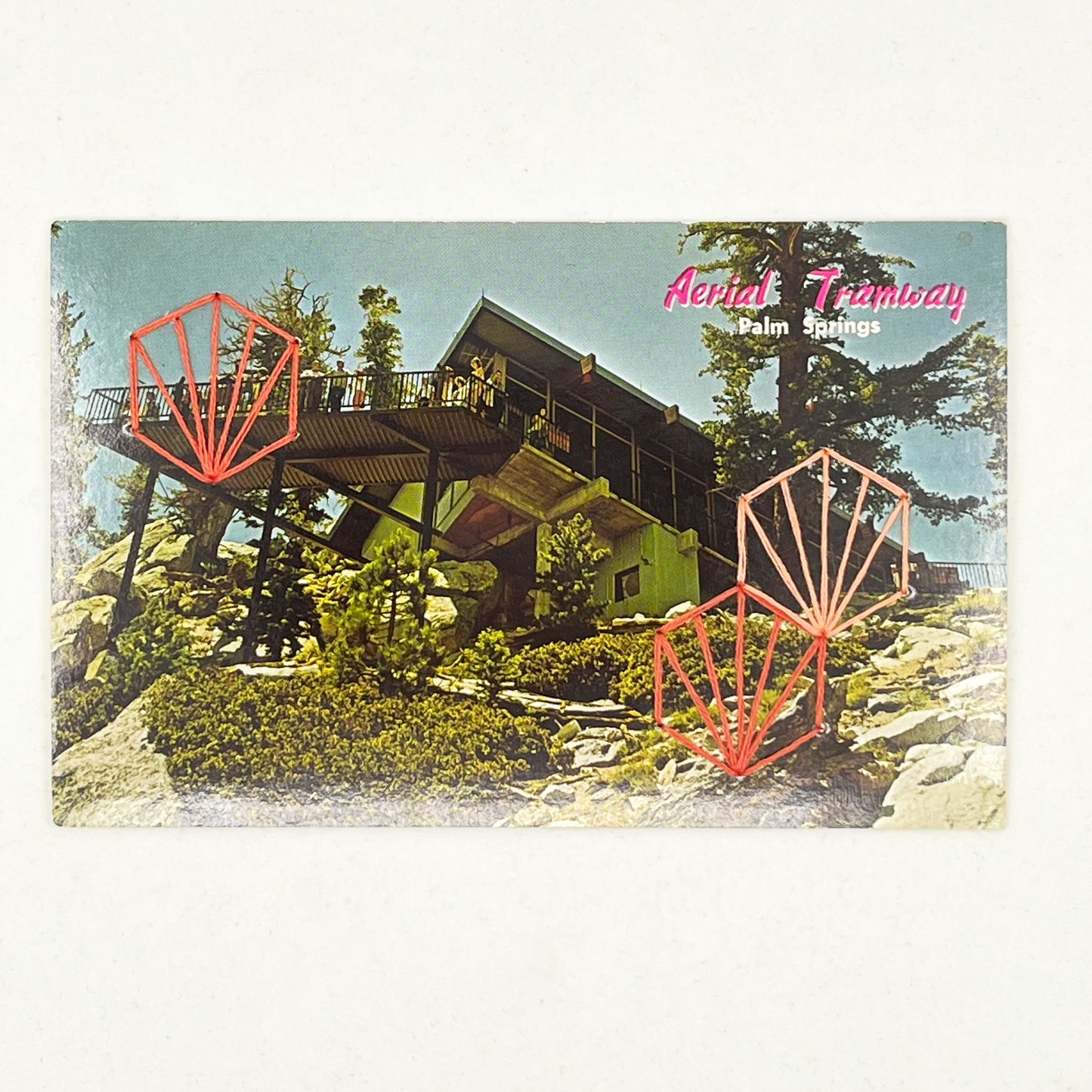 an old postcard of the Palm Springs Aerial Tramway, with coral hand embroidered art deco hexagons randomly placed on it