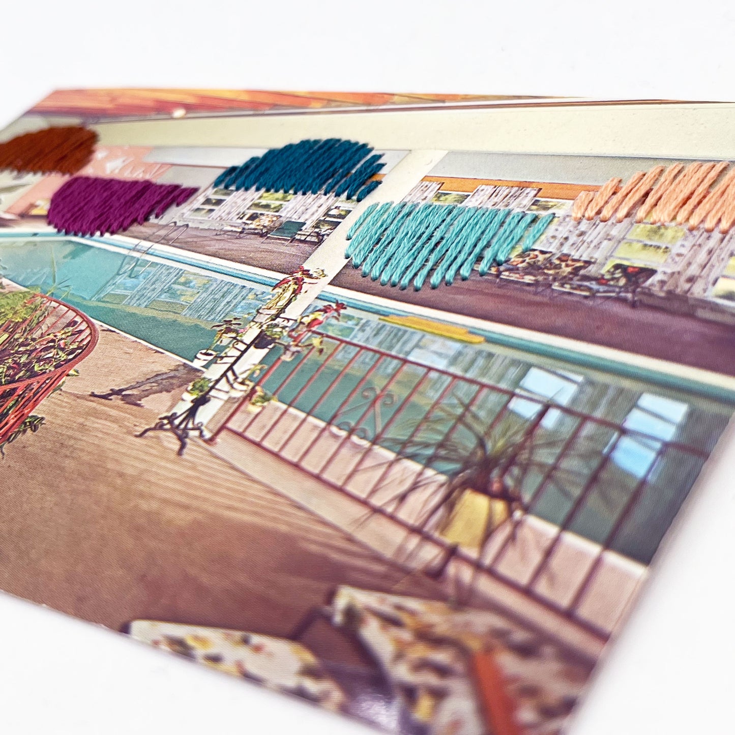 vintage postcard of an indoor pool, with half circles arranged like waves hand embroidered on it in aqua teal plum peach and brown