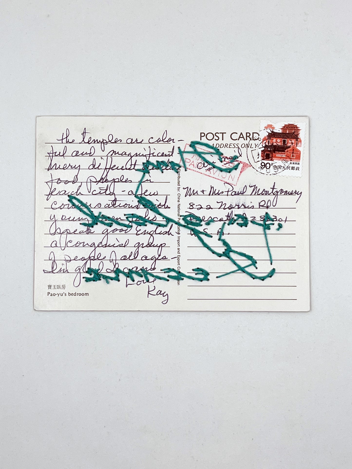 backside of a vintage postcard with a note address and stamp, backside of the words I'm so glad I came hand embroidered in teal cursive backstitch over the top of it
