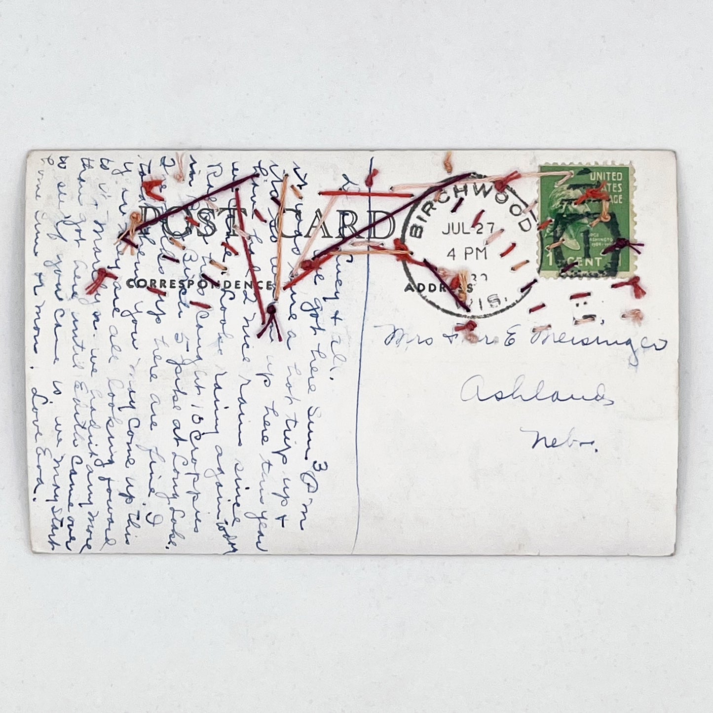 the back of ahand embroidered old postcard of Lake Chetac near Birchwood Wisconsin, original handwritten note in cursive can be seen as well as postmark and stamp