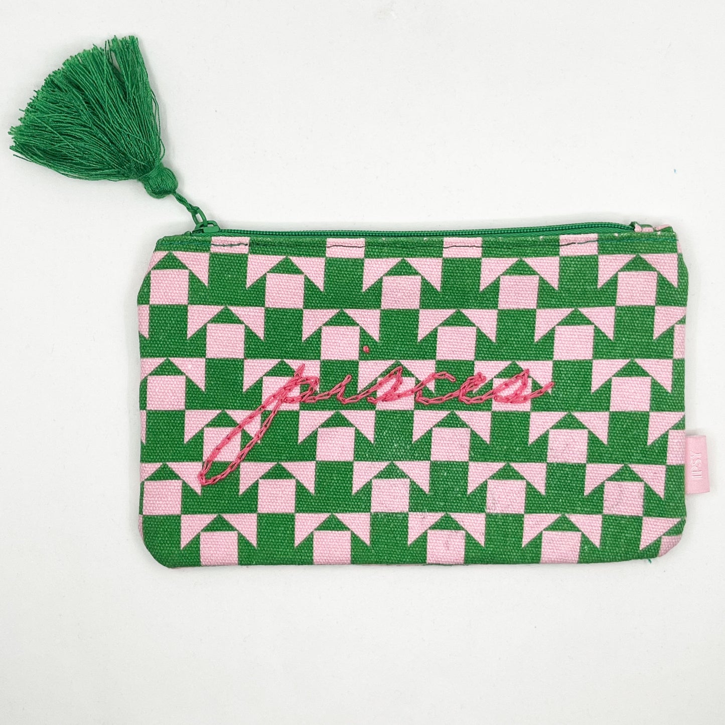 zip pouch with a pink and green geometric design on it hand embroidered in hot pink with the word pisces in chainstitch