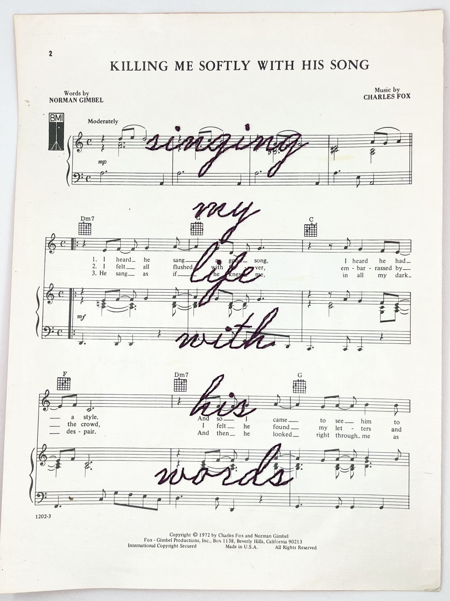 sheet music for the song Killing Me Softly With His Words with the words singing my life with his words hand embroidered over it in eggplant colored thread in cursive, on a white background