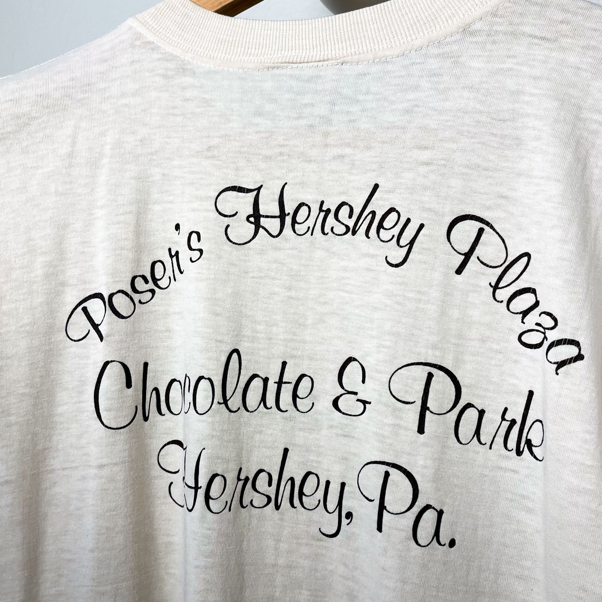 back side of a cream colored t-shirt that says Poser's Hershey Plaza Chocolate & Park Hershey, Pa. in scripty font