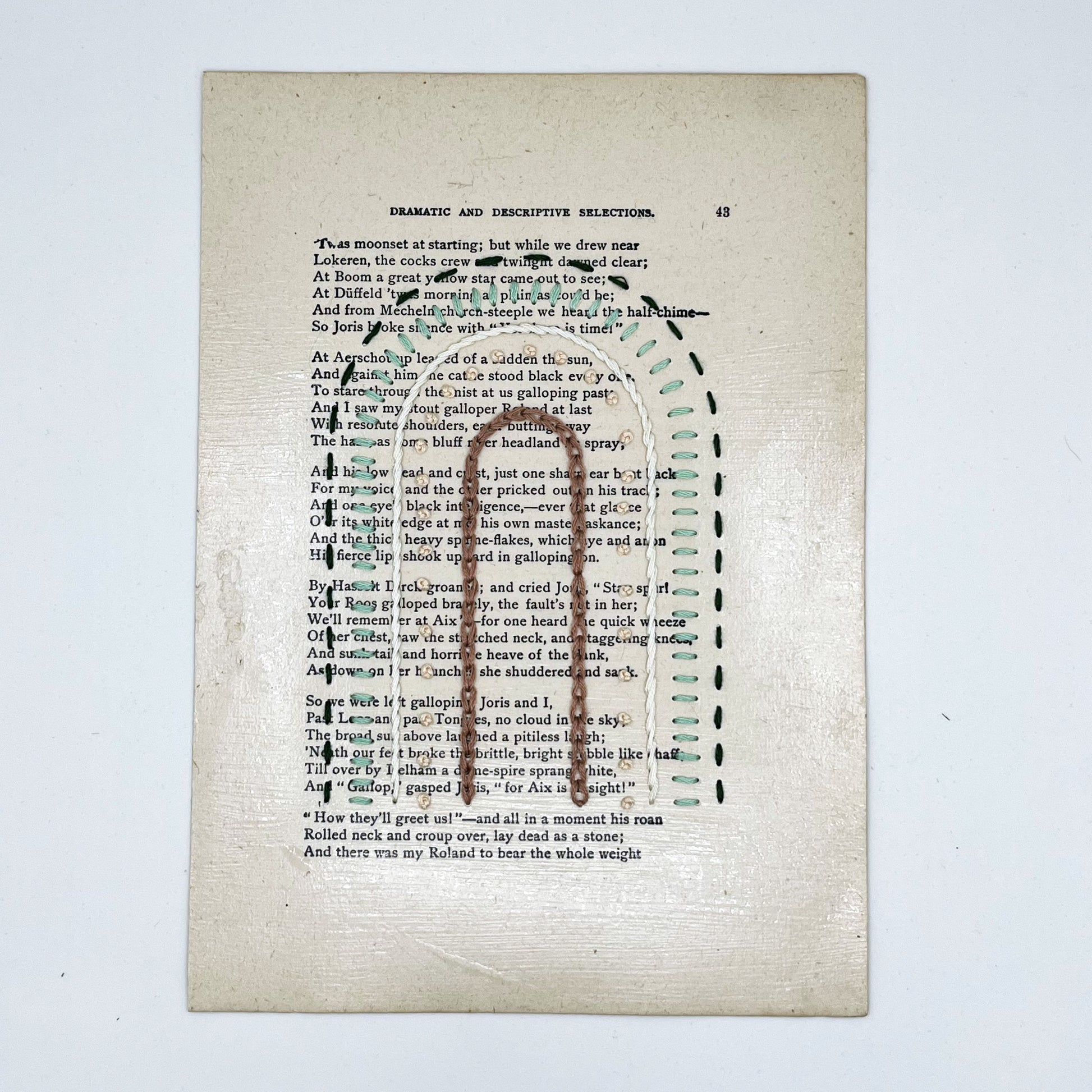 a vintage book page, embroidered with a rainbow of mauve, peach, ivory and greens in different types of embroidery stitches, on a white background