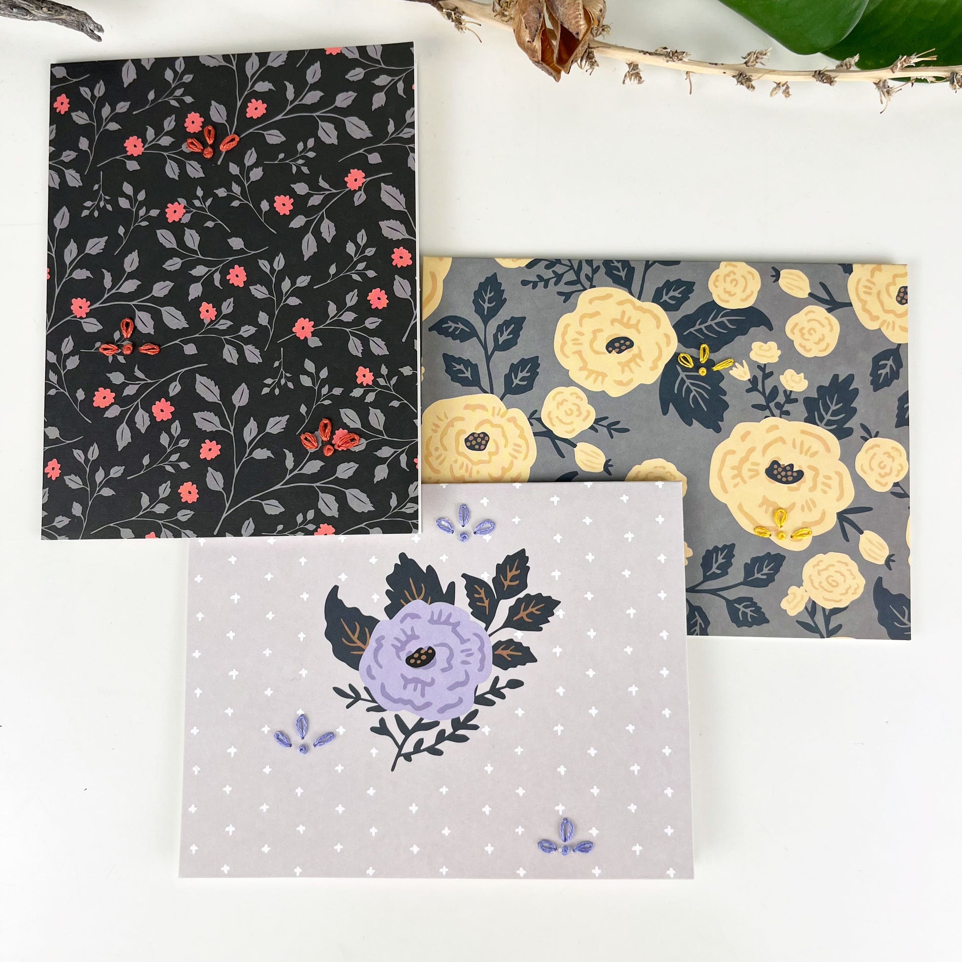 group of three flower greeting cards embellished with small hand embroidered flowers on a white counter