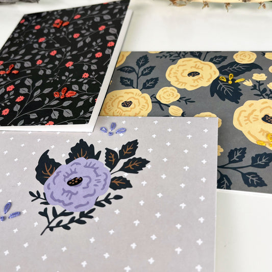 group of three flower greeting cards embellished with small hand embroidered flowers on a white counter