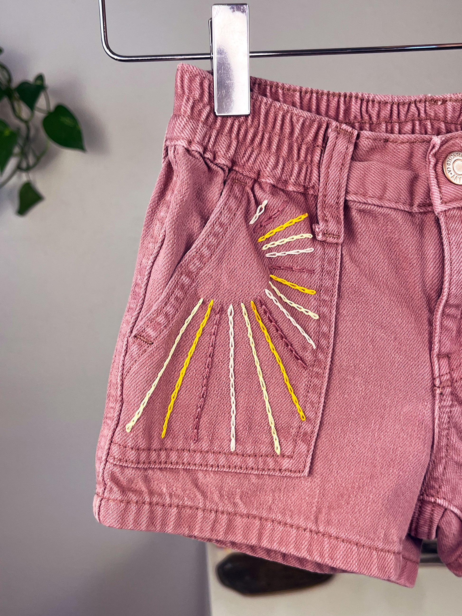 mauve kids shorts with sunbeams hand embroidered in chainstitch on the front pocket