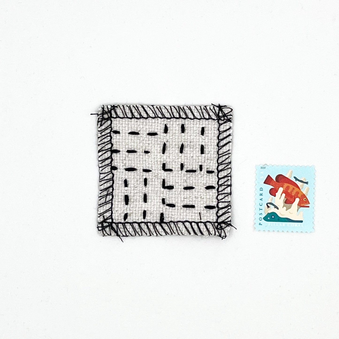 square natural colored patch with stitching in black of a basketweave pattern, next to a stamp for size comparison