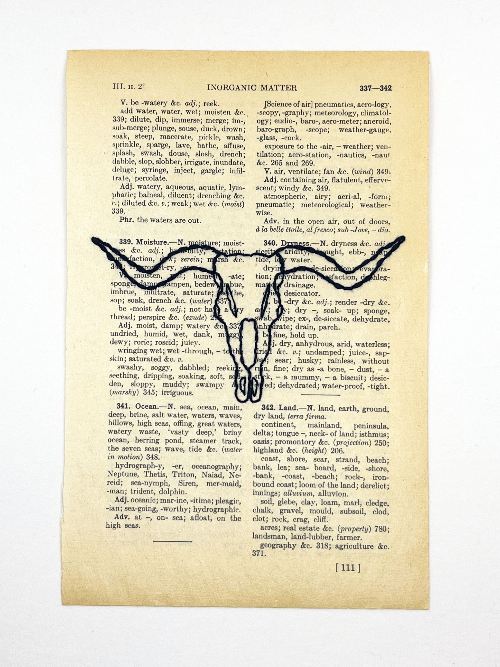 a vintage thesaurus page hand embroidered in black thread with a longhorn skull on a white background
